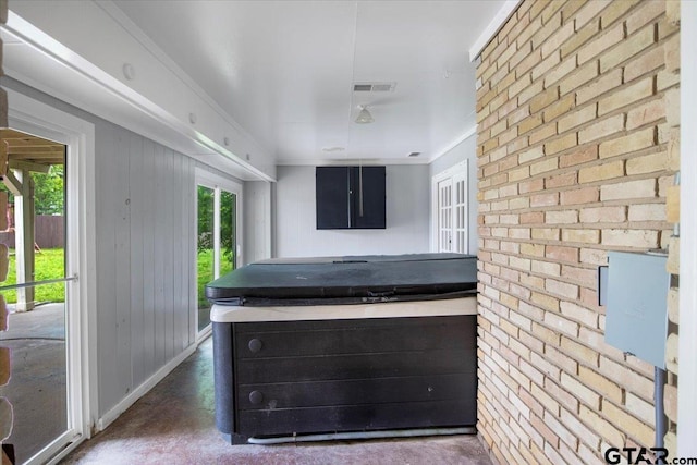 1216 Kingspark Dr, Tyler, TX 75703 - kitchen with plenty of natural light, visible vents, concrete flooring, and brick wall