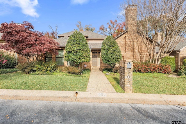 view of property hidden behind natural elements with a front lawn