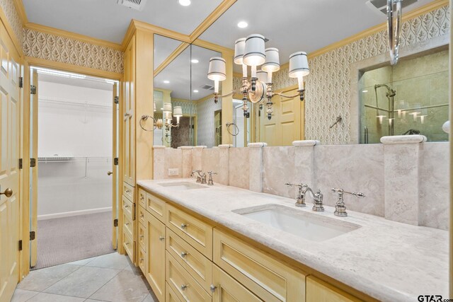 bathroom featuring tile patterned flooring, vanity, a shower with shower door, and ornamental molding