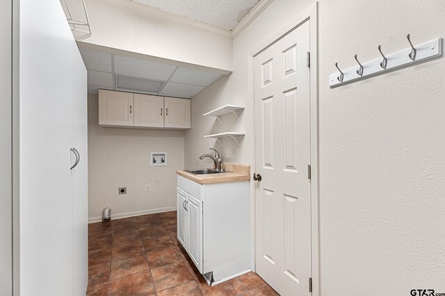 laundry area with hookup for an electric dryer, washer hookup, dark tile patterned flooring, and sink