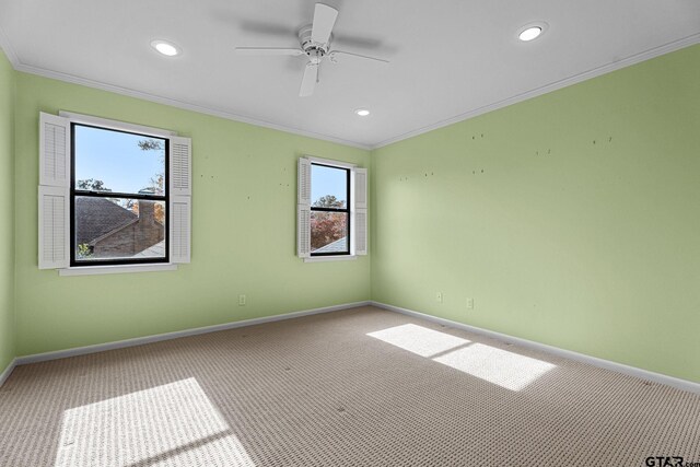 carpeted spare room featuring ceiling fan and ornamental molding