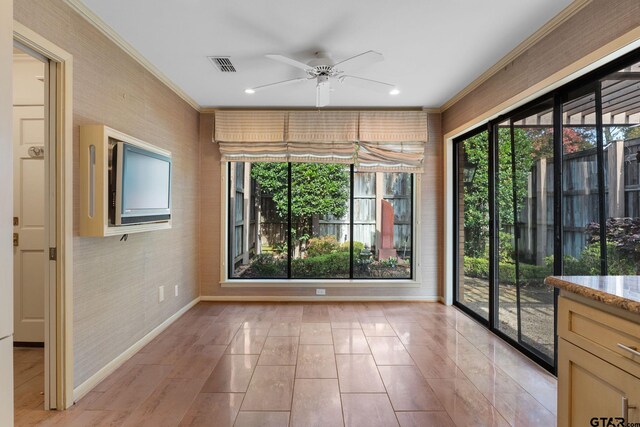 spare room featuring ceiling fan and crown molding