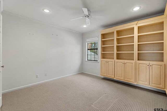 carpeted empty room with crown molding and ceiling fan