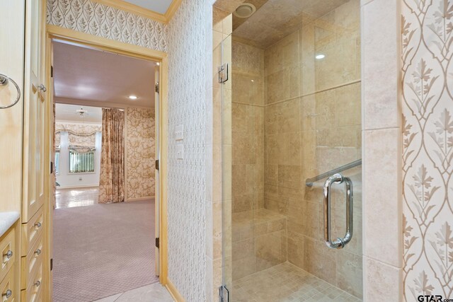 bathroom with an enclosed shower and crown molding