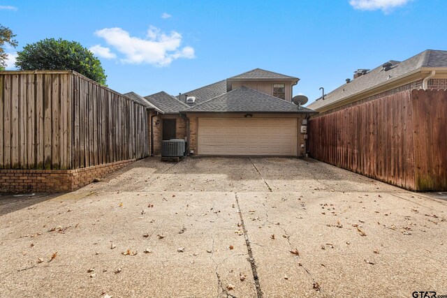 view of side of home with cooling unit and a garage