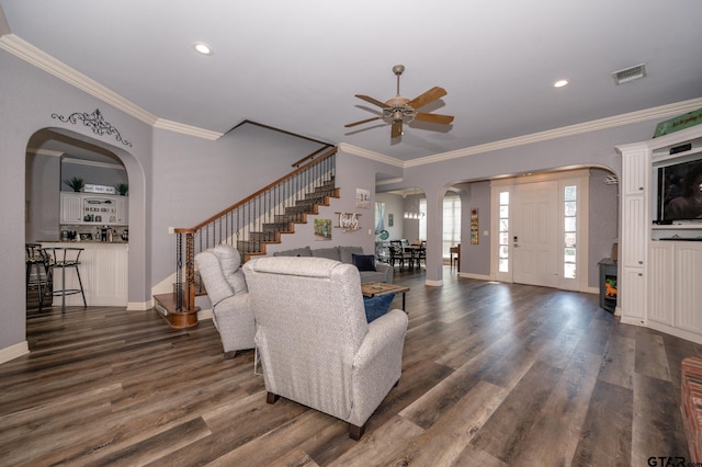 living room with dark wood-type flooring, ceiling fan, and ornamental molding