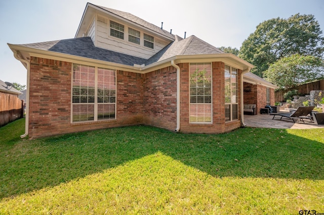 back of property with a yard and a patio area