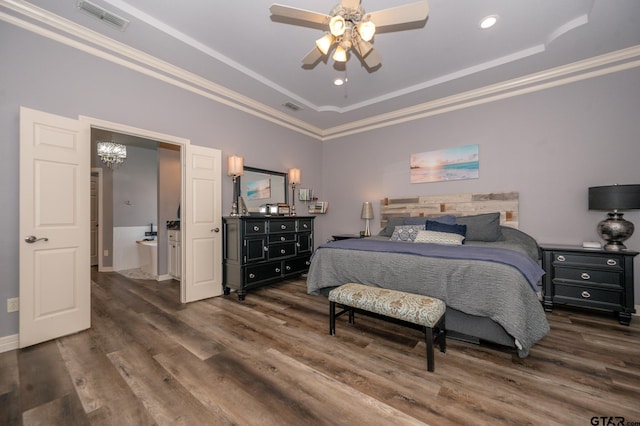 bedroom with ornamental molding, ceiling fan with notable chandelier, dark hardwood / wood-style flooring, and a tray ceiling