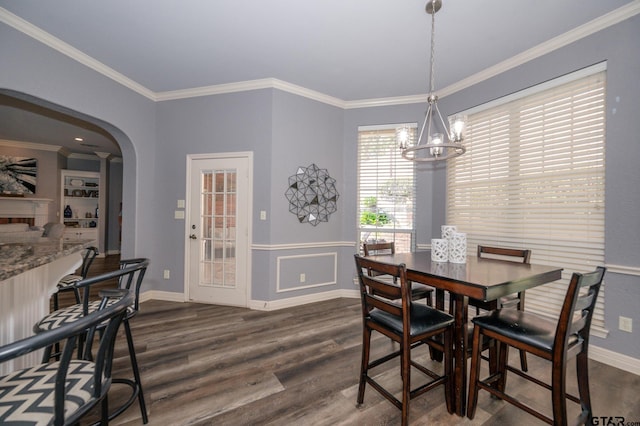 dining space with crown molding, dark hardwood / wood-style flooring, and a notable chandelier