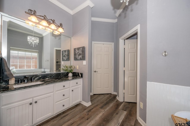 bathroom featuring crown molding, vanity, a chandelier, and hardwood / wood-style flooring