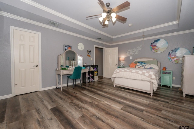 bedroom featuring dark wood-type flooring, a tray ceiling, and crown molding