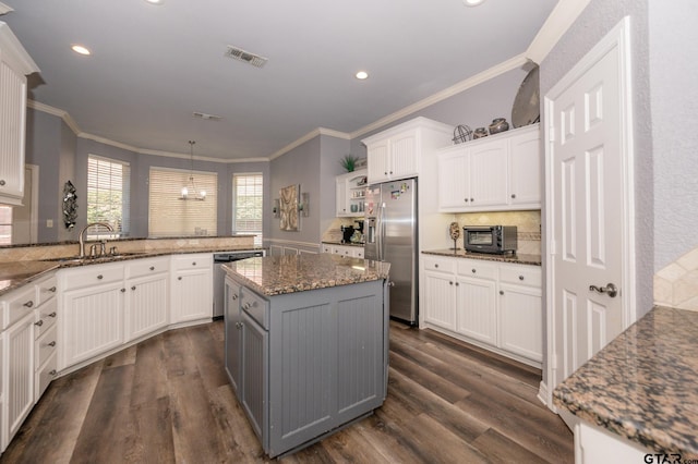 kitchen featuring sink, kitchen peninsula, white cabinets, and appliances with stainless steel finishes