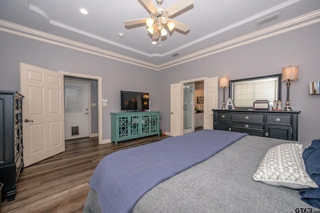 bedroom with dark hardwood / wood-style floors, ornamental molding, and a tray ceiling