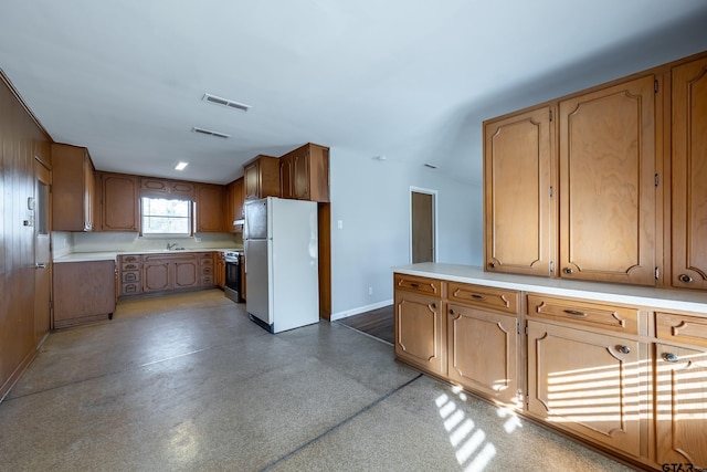 kitchen featuring electric stove, sink, and white fridge