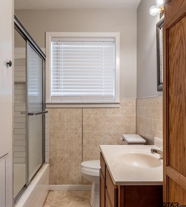 full bathroom with vanity, tile walls, enclosed tub / shower combo, tile patterned flooring, and toilet