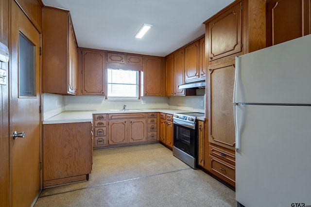 kitchen with stainless steel electric range, white fridge, and sink