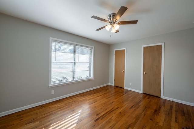 unfurnished bedroom with ceiling fan and dark hardwood / wood-style flooring