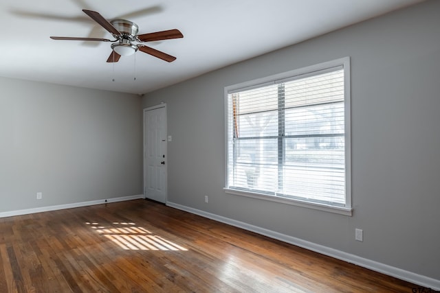 empty room with ceiling fan and dark hardwood / wood-style floors