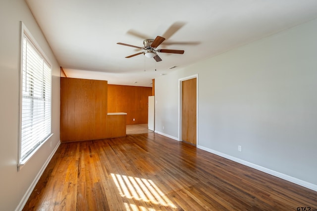 unfurnished room featuring a wealth of natural light, dark hardwood / wood-style flooring, and ceiling fan