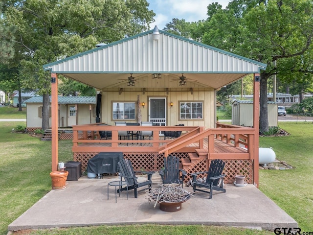 22090 Sportsmans Dr, Chandler, TX 75758 - back of house with an outdoor fire pit, ceiling fan, a lawn, a patio, and a deck