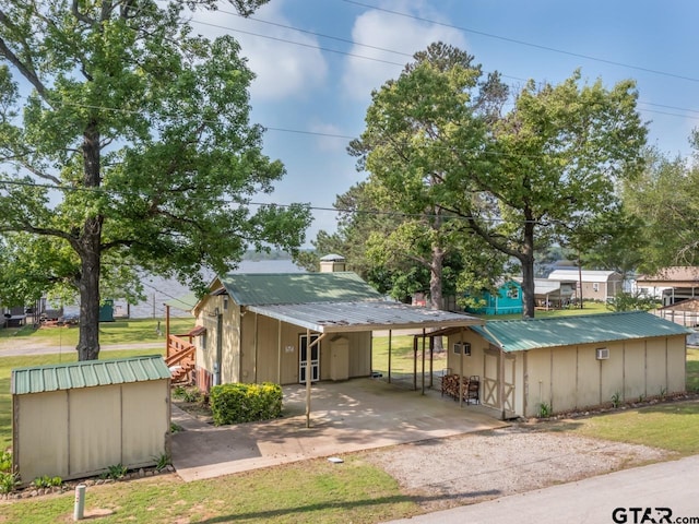 22090 Sportsmans Dr, Chandler, TX 75758 - view of front of home featuring dirt driveway, metal roof, an attached carport, and board and batten siding