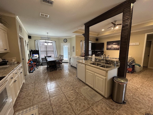 kitchen featuring pendant lighting, dishwasher, sink, a tray ceiling, and crown molding