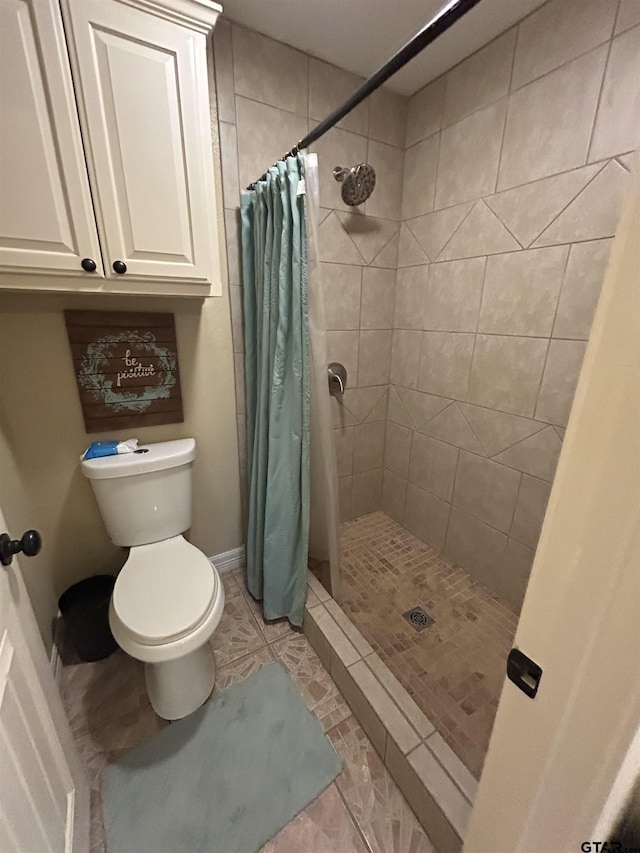 bathroom with tile patterned flooring, toilet, and walk in shower