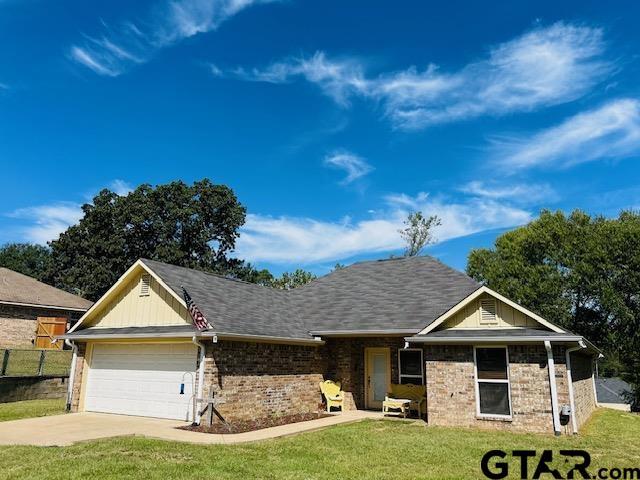 single story home with a garage and a front yard