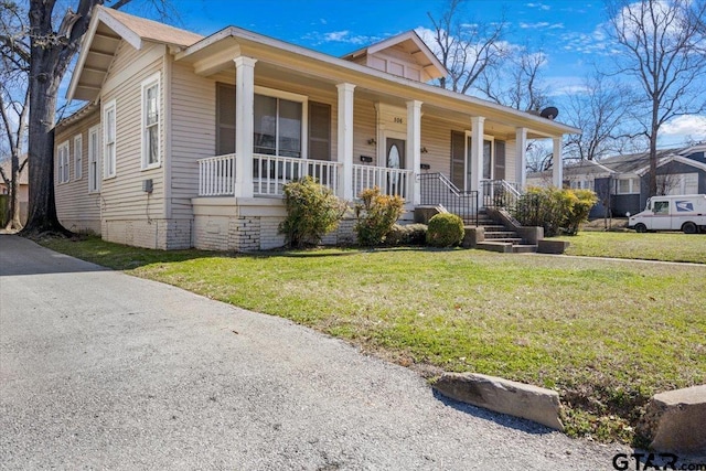 view of front of property featuring covered porch and a front yard