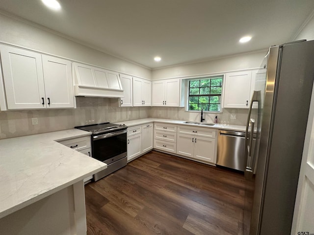 kitchen with stainless steel appliances, white cabinetry, sink, dark hardwood / wood-style floors, and backsplash