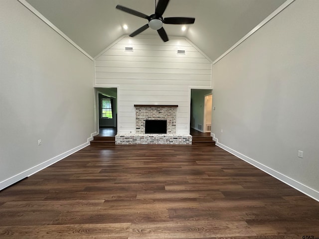 unfurnished living room featuring dark wood-type flooring, ceiling fan, a fireplace, and vaulted ceiling