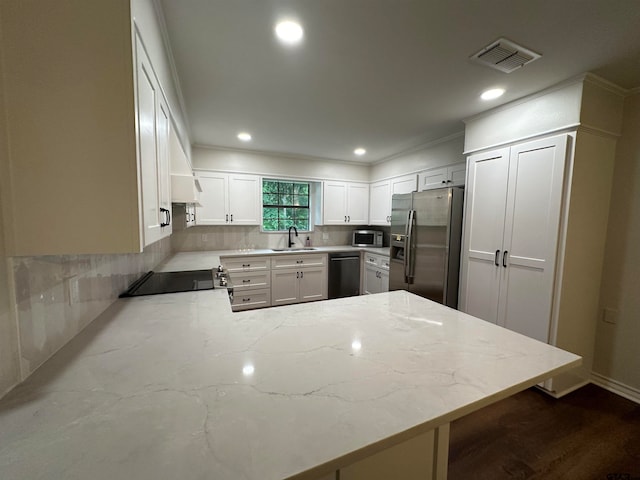 kitchen featuring kitchen peninsula, sink, light stone counters, and appliances with stainless steel finishes