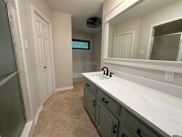 bathroom featuring tile patterned flooring, vanity, and separate shower and tub