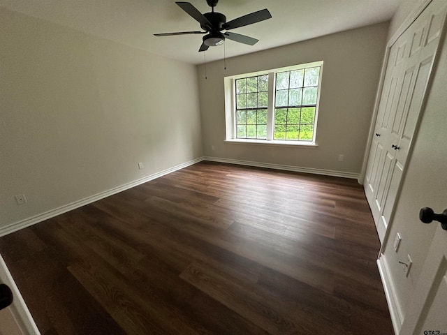 unfurnished bedroom featuring dark hardwood / wood-style flooring, a closet, and ceiling fan