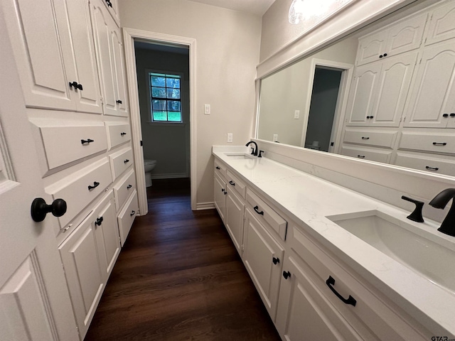 bathroom featuring toilet, vanity, and hardwood / wood-style flooring