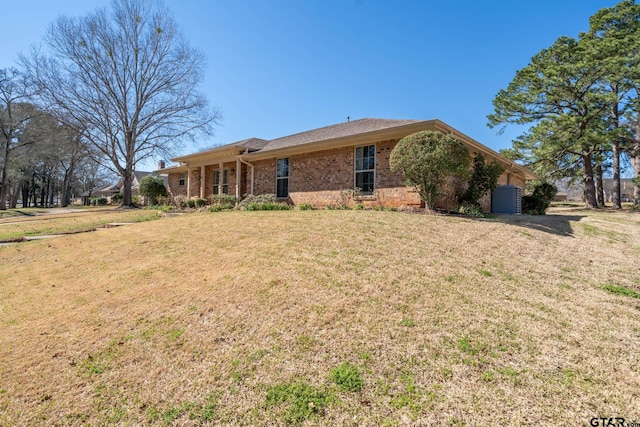 view of front facade with brick siding and a front yard