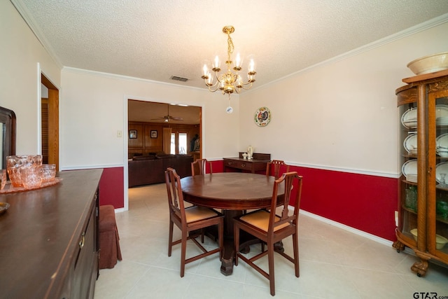 dining area with a textured ceiling, a chandelier, light tile patterned flooring, visible vents, and ornamental molding