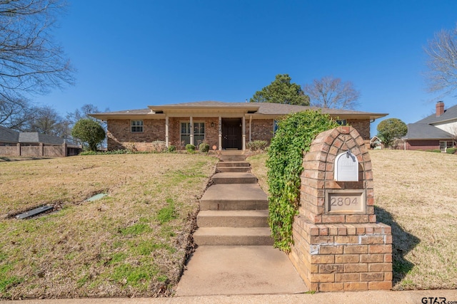 view of front of house featuring a front lawn and brick siding