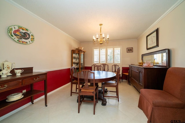 dining space with a wainscoted wall, ornamental molding, and an inviting chandelier