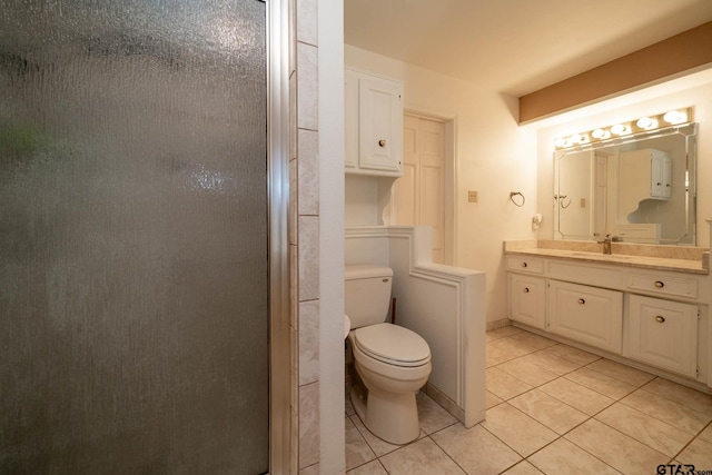 full bathroom featuring toilet, a stall shower, tile patterned flooring, and vanity