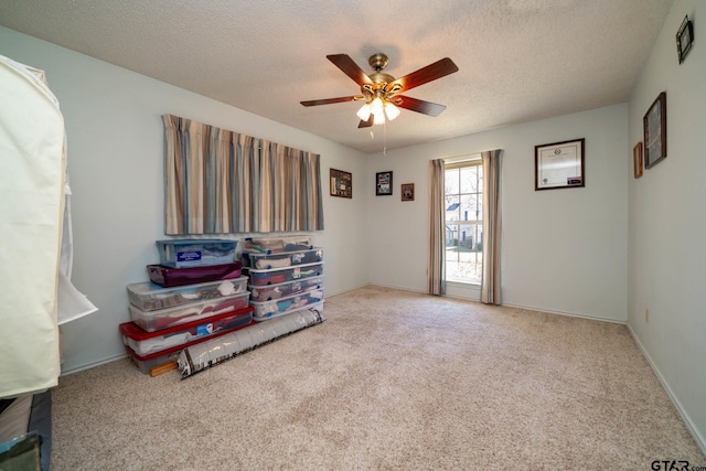 interior space featuring a textured ceiling, ceiling fan, and baseboards