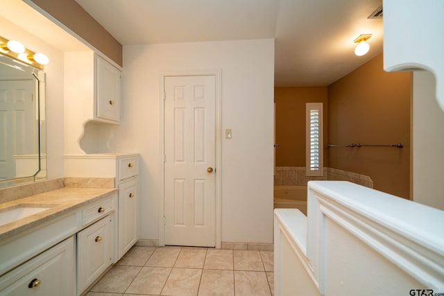 full bath with tile patterned flooring, a bath, and vanity