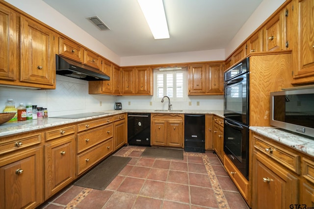 kitchen featuring brown cabinets, a sink, under cabinet range hood, and black appliances