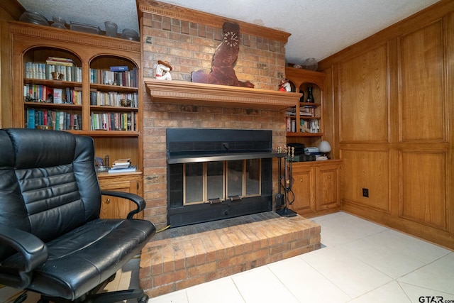 living room with a fireplace, a textured ceiling, and light tile patterned floors