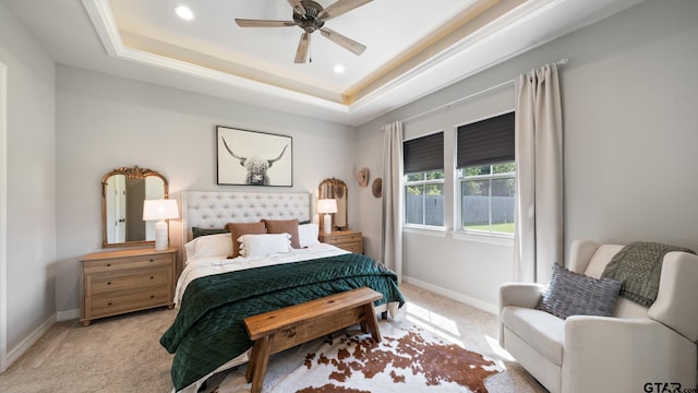 bedroom with recessed lighting, baseboards, light carpet, and a tray ceiling