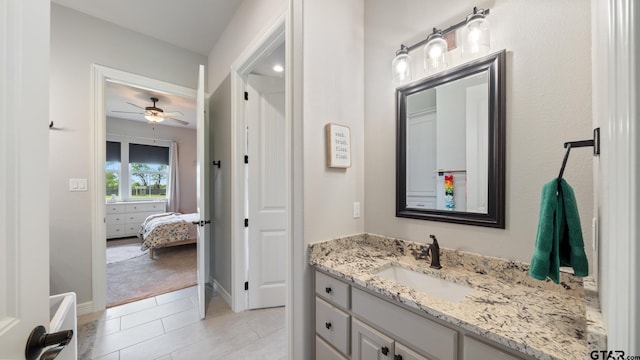 ensuite bathroom with vanity, tile patterned flooring, baseboards, ensuite bathroom, and a ceiling fan