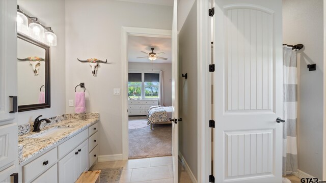 bathroom with vanity, tile patterned flooring, baseboards, ceiling fan, and ensuite bath