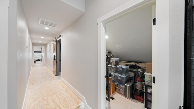 hallway featuring baseboards, recessed lighting, a barn door, and visible vents