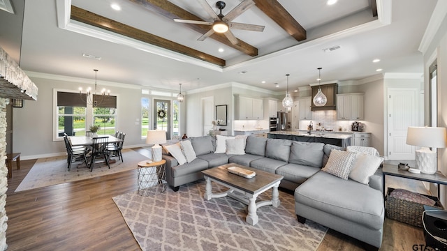 living room featuring visible vents, recessed lighting, a raised ceiling, and ceiling fan with notable chandelier