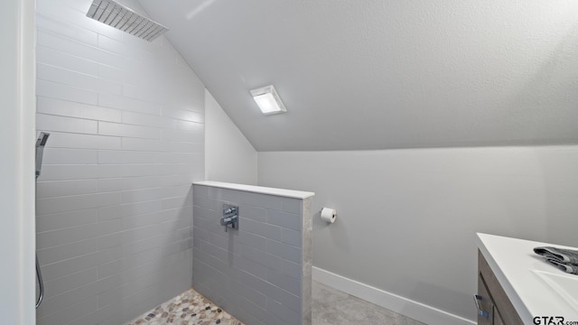 full bath with vanity, baseboards, lofted ceiling, visible vents, and tiled shower